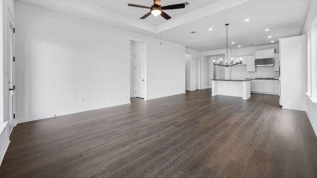 113 Golden Sage Ave, Georgetown, TX 78633 - unfurnished living room featuring recessed lighting, ceiling fan, a chandelier, dark wood-type flooring, and a raised ceiling