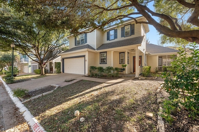 traditional-style house featuring a shingled roof, concrete driveway, covered porch, and an attached garage