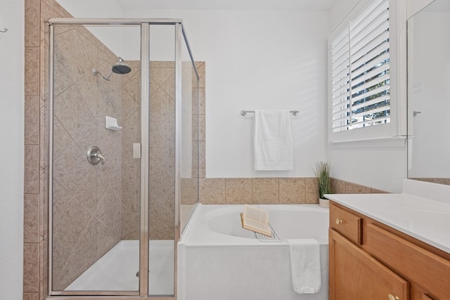 full bathroom with a stall shower, vanity, and a bath