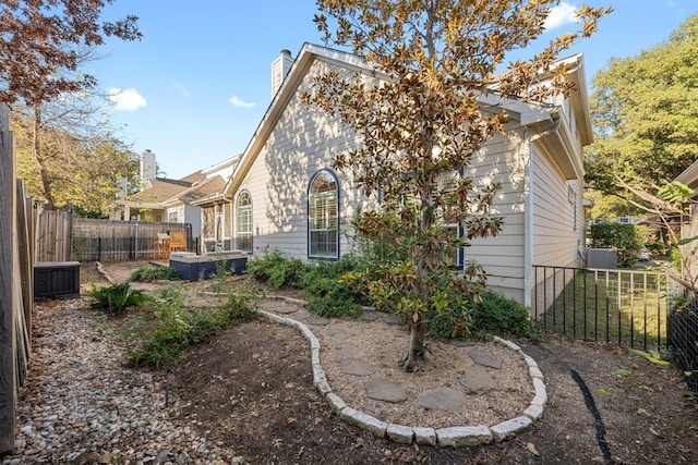 rear view of house featuring a fenced backyard and a chimney