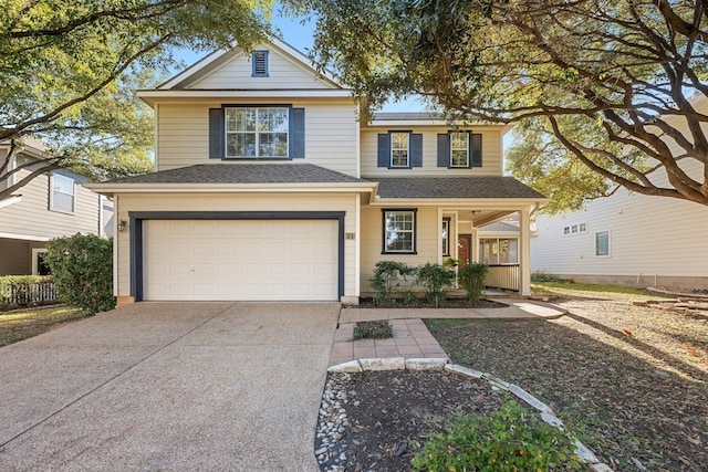 traditional home featuring a garage, driveway, and a shingled roof