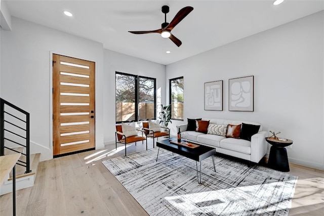 living room featuring ceiling fan and light hardwood / wood-style flooring