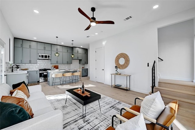 living room with ceiling fan and light hardwood / wood-style floors