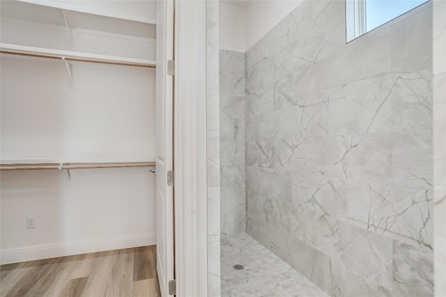 189 Mauna Kea Ln, Bastrop, TX 78602 - bathroom featuring a walk in closet, wood finished floors, and a marble finish shower