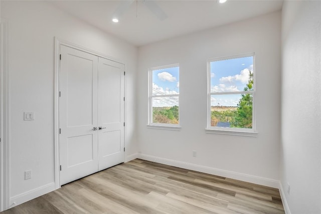 unfurnished bedroom featuring ceiling fan, a closet, and light hardwood / wood-style floors