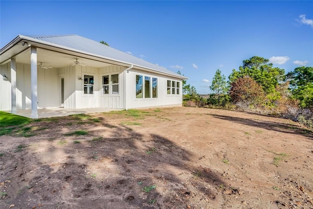 189 Mauna Kea Ln, Bastrop, TX 78602 - back of house featuring a ceiling fan, board and batten siding, a patio, metal roof, and dirt driveway