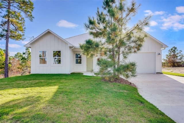 189 Mauna Kea Ln, Bastrop, TX 78602 - modern farmhouse style home featuring concrete driveway, an attached garage, a front yard, board and batten siding, and metal roof