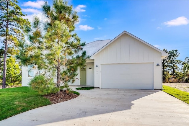 189 Mauna Kea Ln, Bastrop, TX 78602 - view of front of house featuring an attached garage, driveway, a front yard, and metal roof