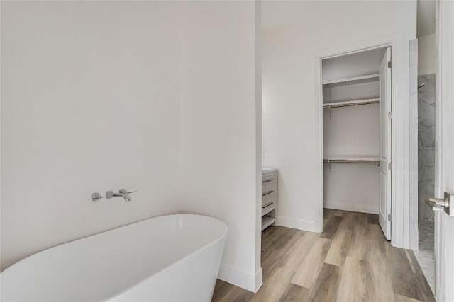 189 Mauna Kea Ln, Bastrop, TX 78602 - full bath featuring a freestanding tub, a spacious closet, wood finished floors, vanity, and baseboards