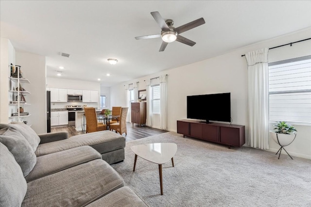 living room featuring light wood-type flooring and ceiling fan