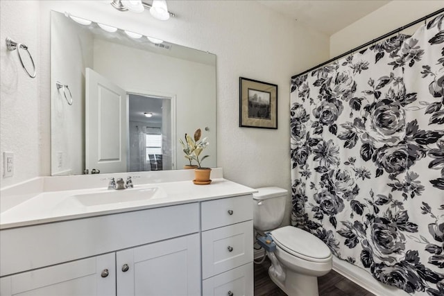 bathroom featuring vanity, hardwood / wood-style flooring, toilet, and curtained shower