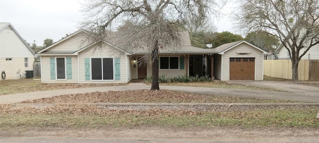 view of front of home with a garage and central air condition unit