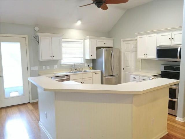 kitchen with white cabinetry, sink, stainless steel appliances, and a kitchen island