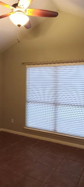 tiled empty room featuring ceiling fan and vaulted ceiling