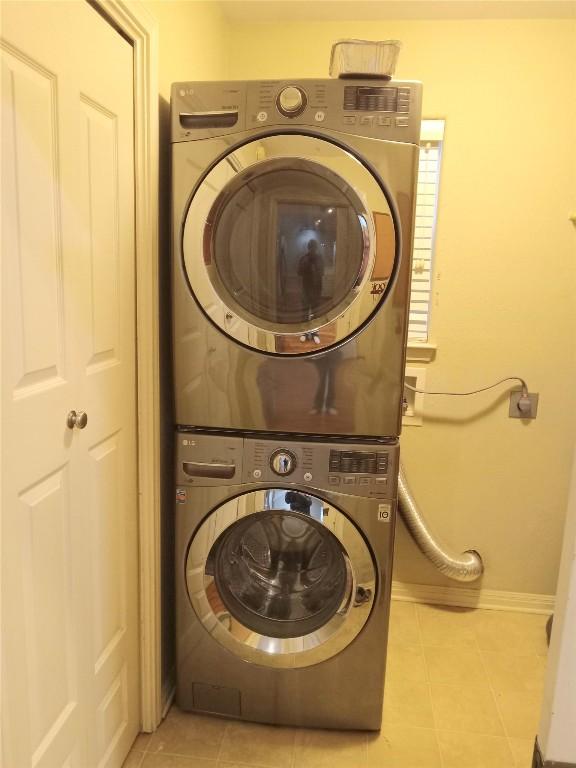 clothes washing area with stacked washer / dryer