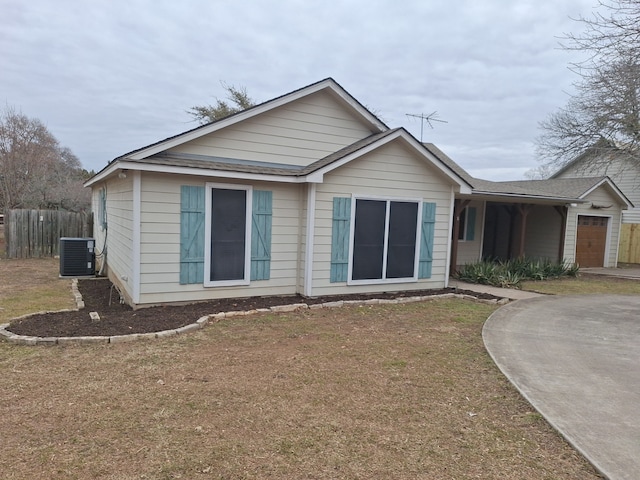 exterior space featuring a garage, cooling unit, and a yard