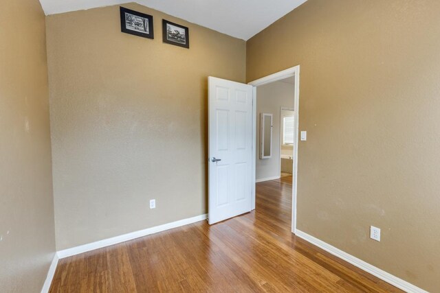 empty room featuring baseboards and wood finished floors