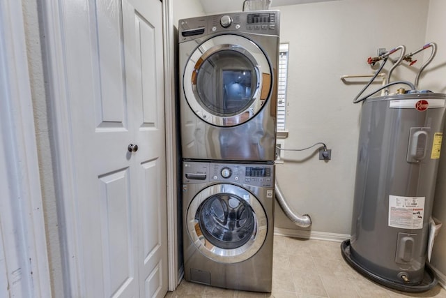 clothes washing area featuring laundry area, tile patterned flooring, baseboards, stacked washing maching and dryer, and water heater