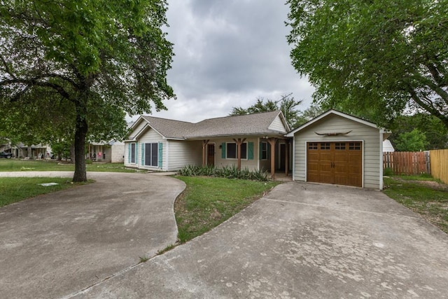 ranch-style home featuring a front lawn, fence, and driveway