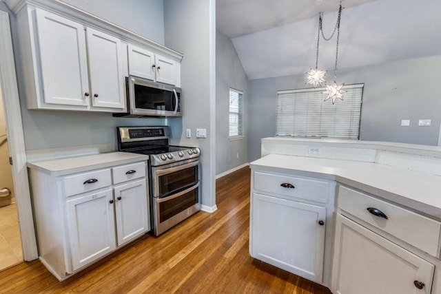 kitchen featuring light countertops, white cabinets, stainless steel appliances, and lofted ceiling