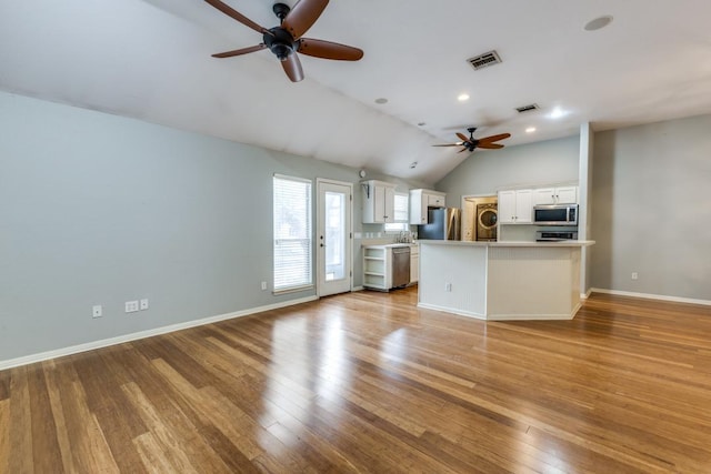 unfurnished living room with a ceiling fan, visible vents, lofted ceiling, and light wood-type flooring