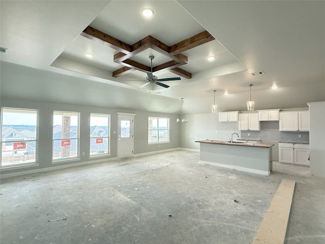 kitchen featuring white cabinets, ceiling fan, pendant lighting, sink, and a kitchen island with sink