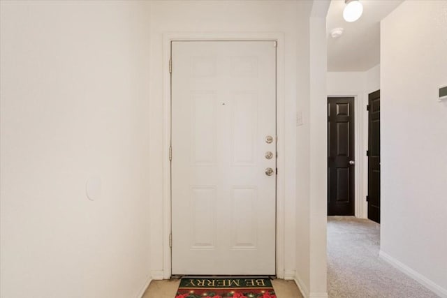 doorway to outside featuring light carpet