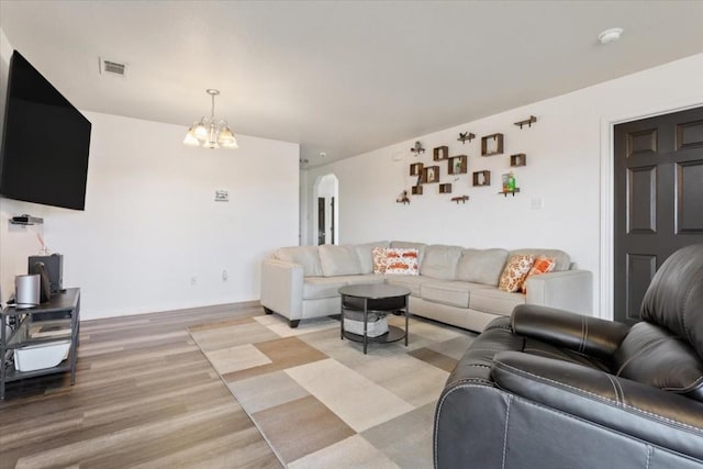 living room featuring a chandelier and light hardwood / wood-style flooring