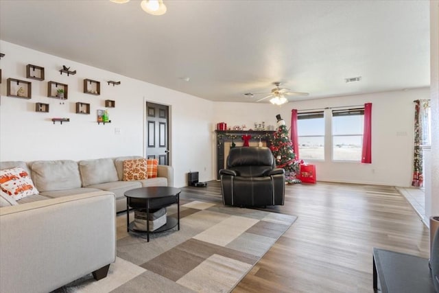 living room featuring ceiling fan and light hardwood / wood-style floors