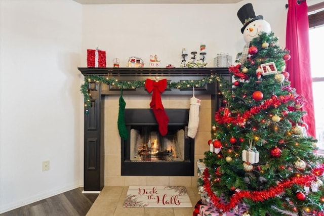 details featuring a tiled fireplace and hardwood / wood-style floors