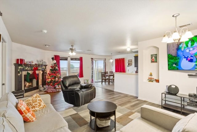 living room with hardwood / wood-style flooring and ceiling fan with notable chandelier