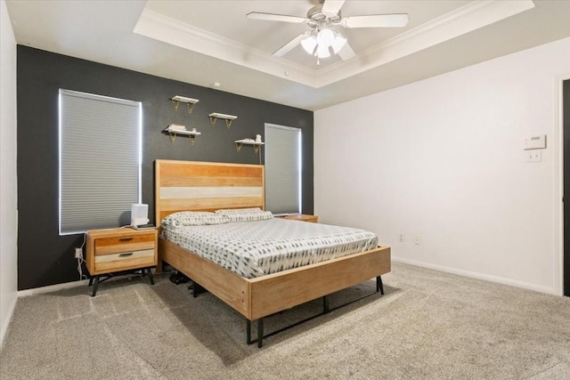 bedroom with carpet floors, a raised ceiling, ceiling fan, and crown molding