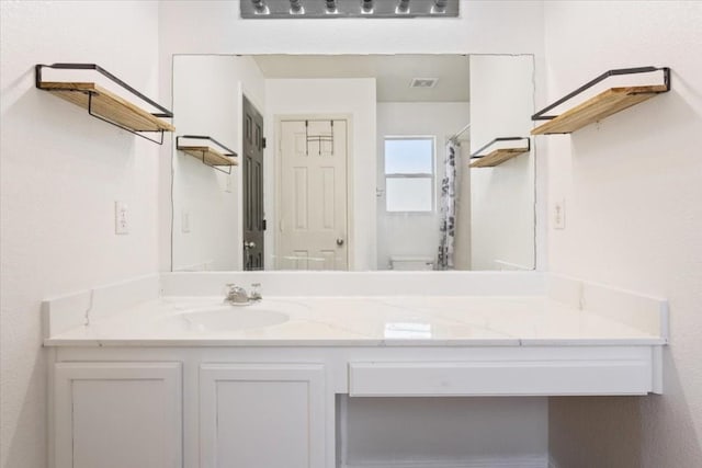 bathroom with vanity, a shower with shower curtain, and toilet