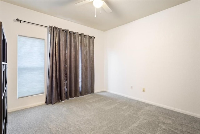 carpeted spare room featuring ceiling fan