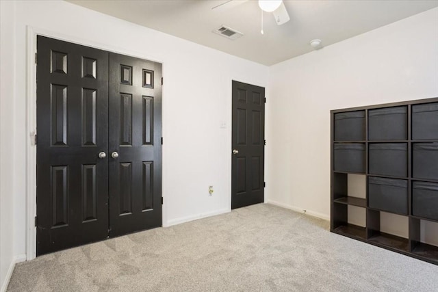 unfurnished bedroom featuring ceiling fan, light carpet, and a closet