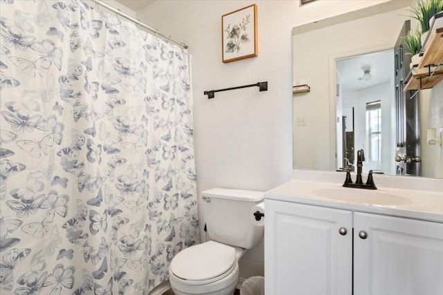 bathroom featuring vanity, toilet, and walk in shower