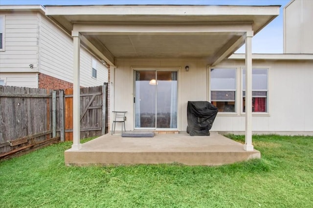 rear view of property featuring a lawn and a patio area