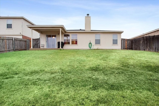 rear view of property featuring a lawn