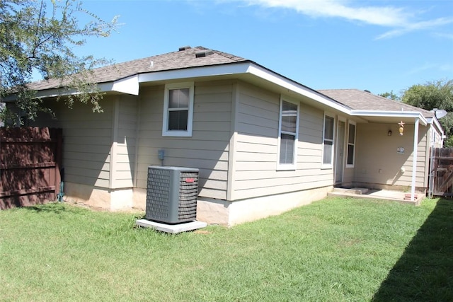 rear view of property with a yard and central AC unit