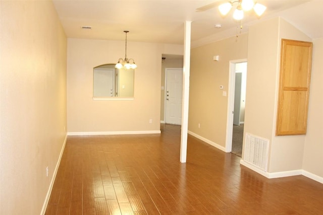 unfurnished room with dark hardwood / wood-style flooring and ceiling fan with notable chandelier