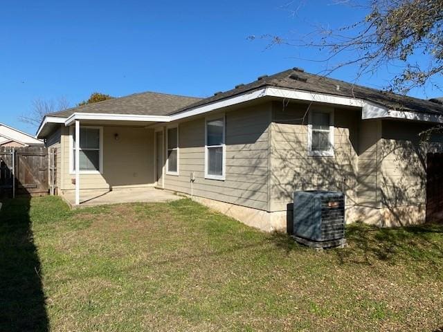 back of house with central AC unit, a patio, and a lawn