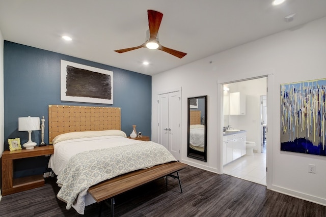 bedroom featuring hardwood / wood-style floors, ensuite bathroom, sink, ceiling fan, and a closet