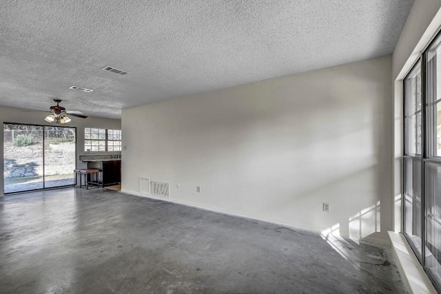 unfurnished living room with ceiling fan and a textured ceiling