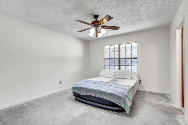 bedroom with ceiling fan, concrete flooring, and a textured ceiling