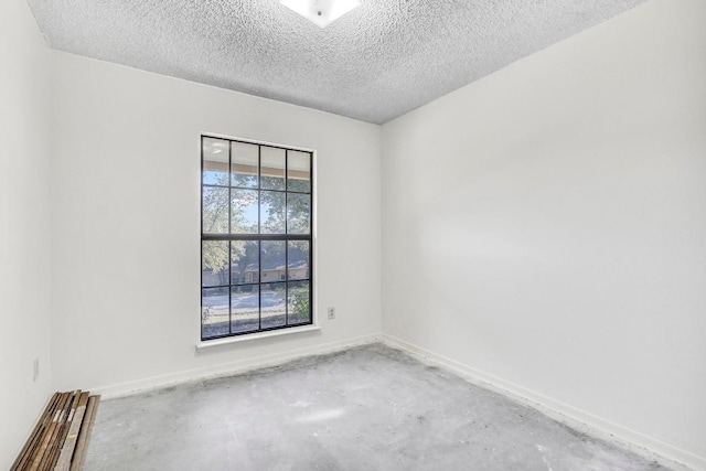 unfurnished room featuring a textured ceiling and concrete floors