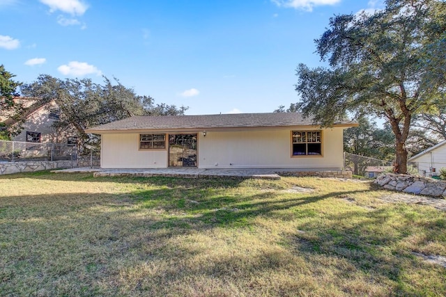 rear view of property featuring a lawn