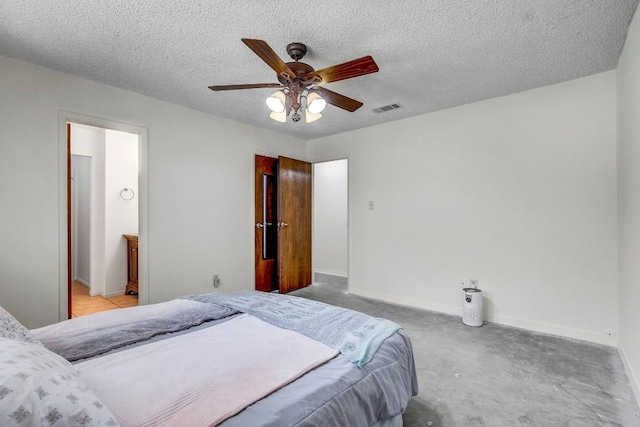 bedroom featuring ensuite bath, ceiling fan, and a textured ceiling