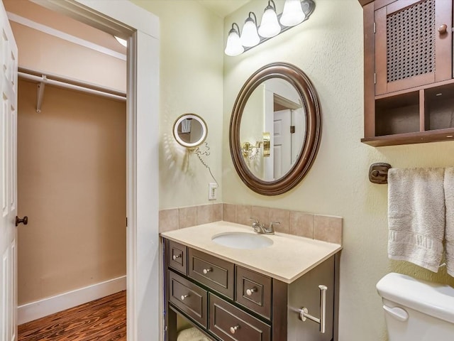 bathroom with hardwood / wood-style flooring, vanity, and toilet