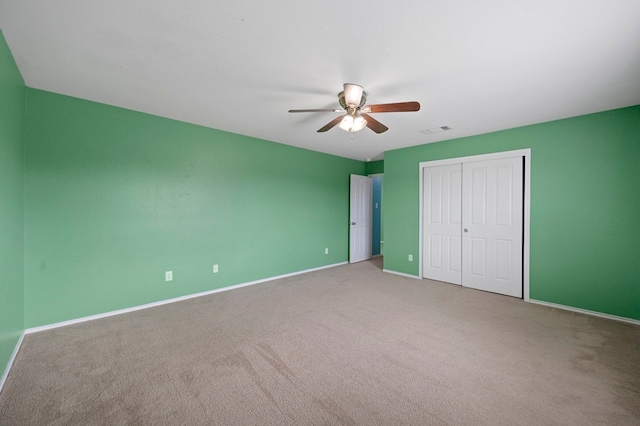 unfurnished bedroom with light colored carpet, a closet, and ceiling fan