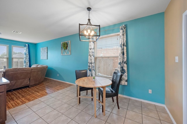 tiled dining space featuring a notable chandelier